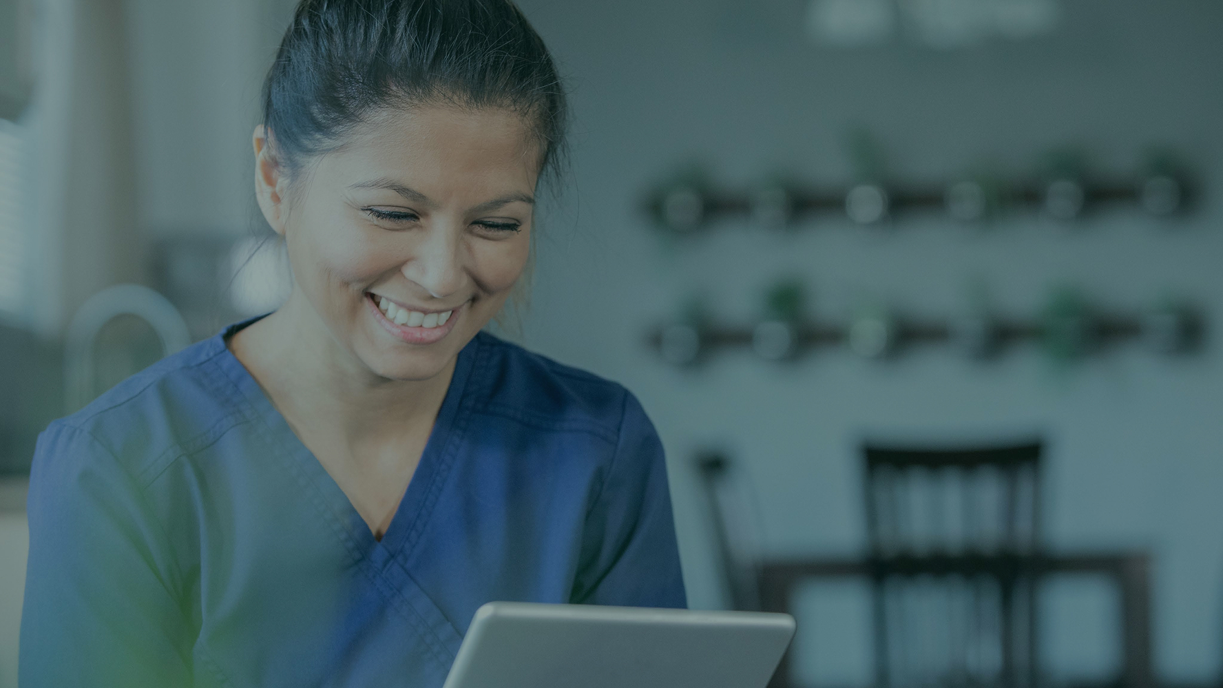 Health practitioner smiling and looking in the tablet